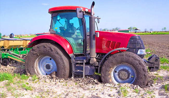 Uvíznutý traktor s prokluzujícími koly